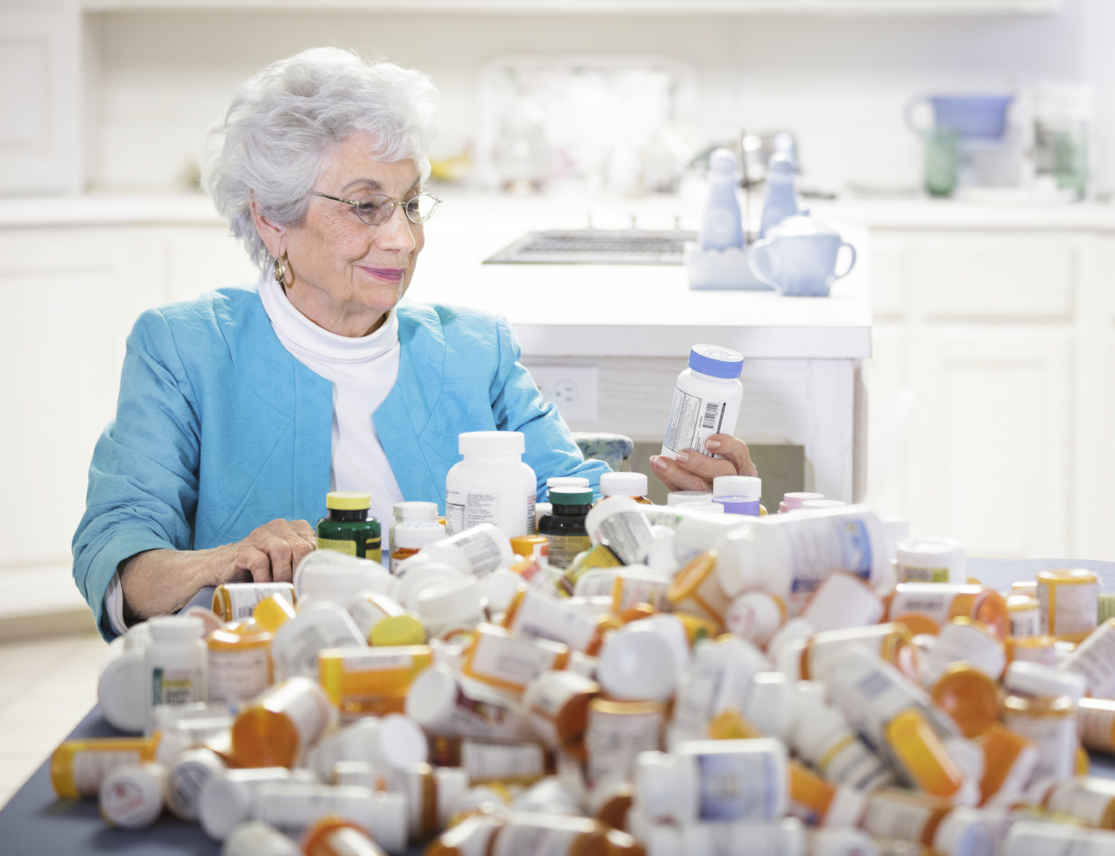 Senior woman with mountain of pill bottles