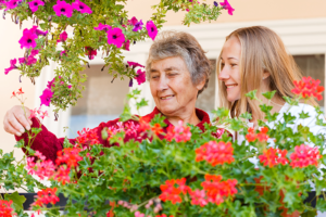 senior with alzheimers enjoying flowers outside